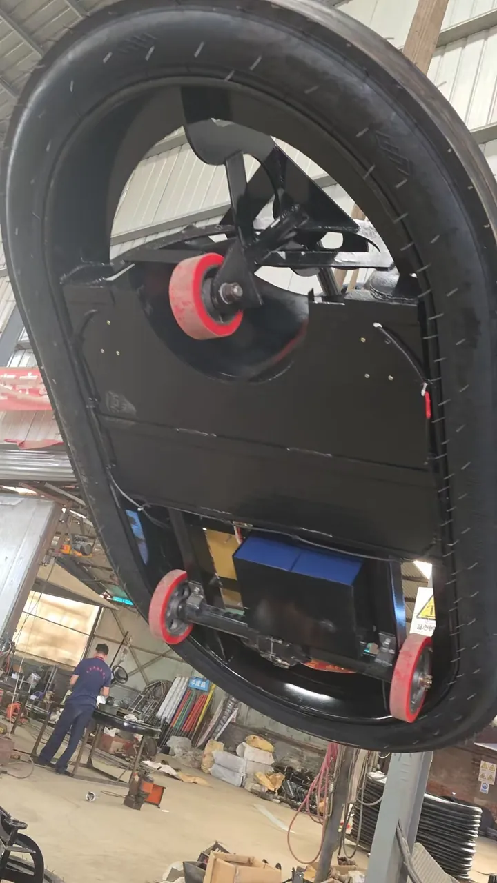 Underside of a bumper car showing the full-perimeter inflatable rubber bumper and drive wheels