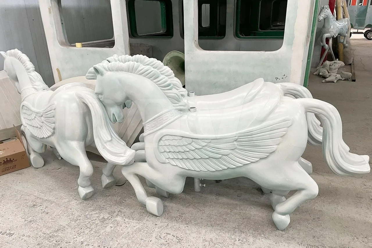 Raw hand-laid fiberglass horses straight out of the mold — including a pair of winged horses for a themed order.