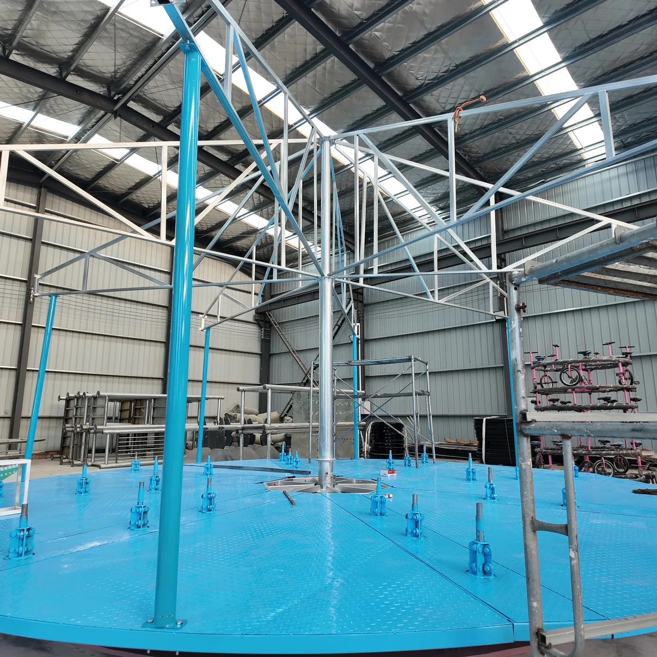 Platform, standing poles and upper frame of a deluxe unit during assembly. The blue deck is aluminum-faced board, not painted steel.