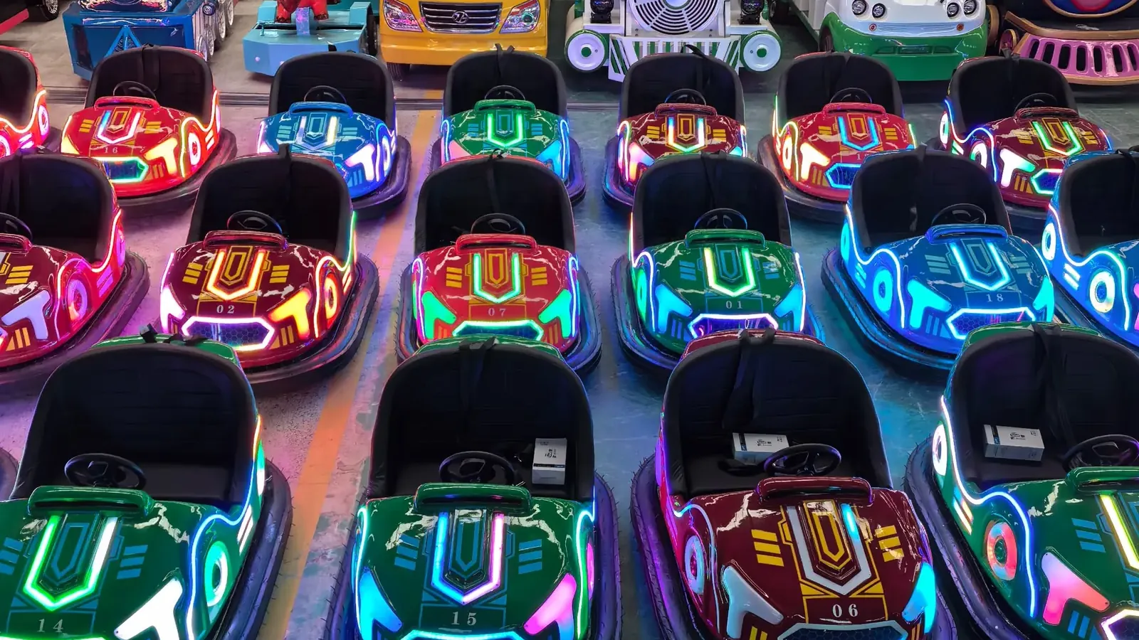 Rows of LED-lit battery bumper cars lined up at the XL Amusement Ride factory
