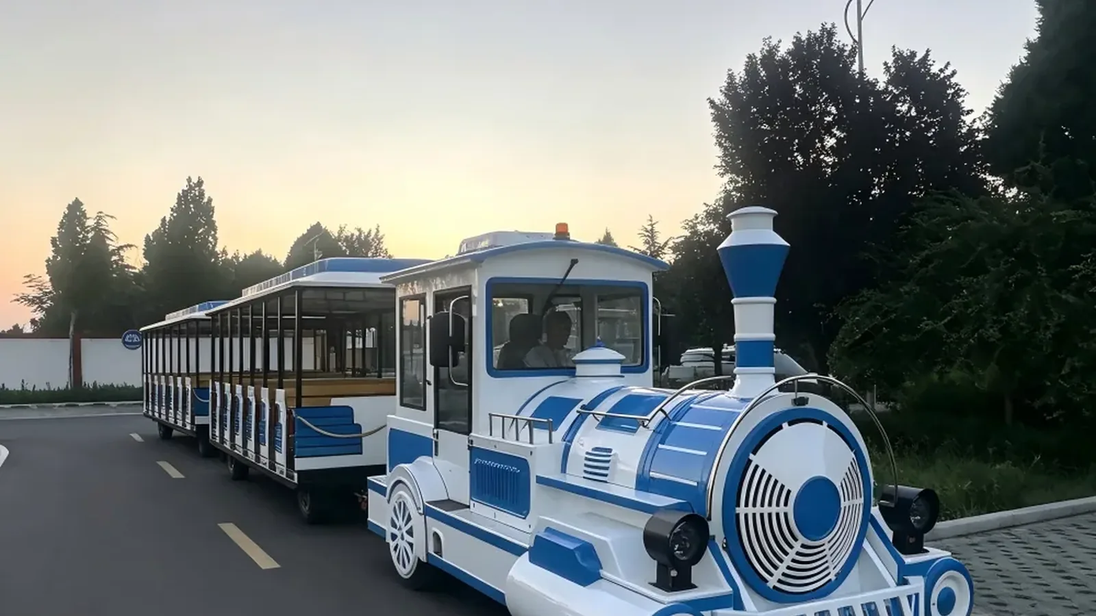 An electric trackless sightseeing train with two carriages running in a park
