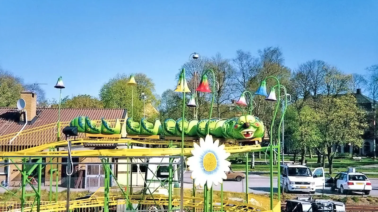 A compact worm family coaster with cars cresting the lift hill